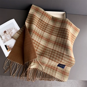 Detail shot of brown plaid cashmere-like scarf with fringe edges and brand label
