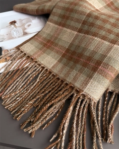 Detailed macro view of checkered cashmere scarf texture and hand-twisted fringe edges