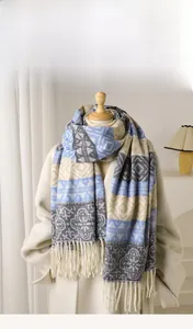 Ethnic scarf in blue and white with geometric patterns and long tassels on a model