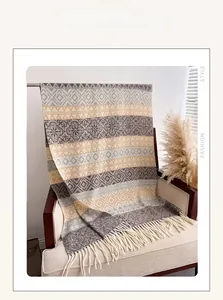 Detail of bohemian cashmere-feel scarf with ethnic patterns and soft cream-colored tassels
