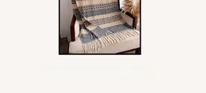 Close-up of bohemian shawl fringe detail and geometric knit pattern on an armchair