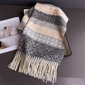 Close-up of geometric pattern knit scarf with fringe tassels in a stylish display box