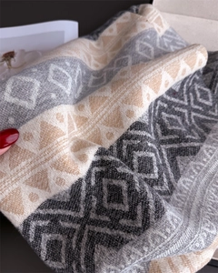 Close-up of geometric jacquard pattern on thick knitted ethnic style tassel scarf