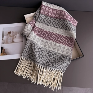 Detail of bohemian cashmere-like shawl featuring geometric patterns and fringe tassels