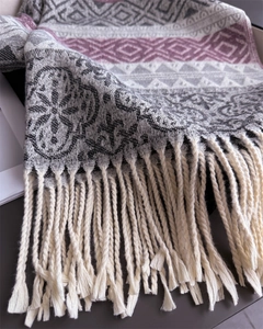 Close-up of ethnic jacquard knit shawl with geometric patterns and beige tassels