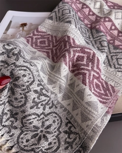 Detailed close-up of geometric pattern and soft fringe on this warm cashmere-like scarf