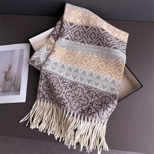 Close-up of ethnic geometric pattern jacquard scarf with creamy white tassels in gift box