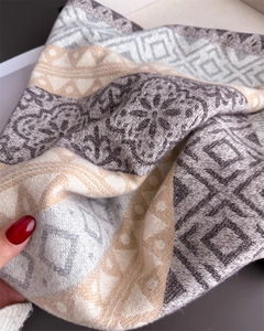 Macro shot of ethnic geometric jacquard knit scarf with tassels and soft fabric texture