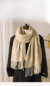 Detail of cream cashmere-feel scarf with white paisley pattern and fringe trim