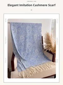 Detail of light blue paisley pattern scarf with soft white tassels on a wooden chair