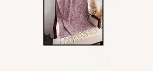 Close-up of paisley pattern and soft white tassel trim on a burgundy cashmere-style scarf