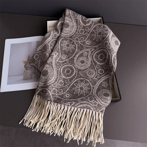 Macro detail of brown paisley patterned cashmere-feel scarf with delicate fringe edges
