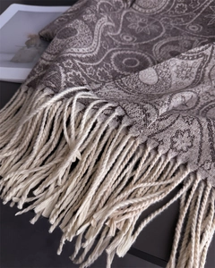 Detailed close-up of paisley pattern and soft fringe tassels on cashmere-feel scarf