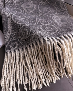 Detailed close-up of dark grey paisley scarf showing soft fringe and warm knit texture