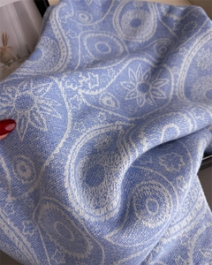 Close-up of blue paisley pattern pashmina with soft knitted cashmere texture and fringes