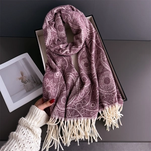 Detail of a deep purple scarf with mandala paisley patterns and soft fringes in a gift box