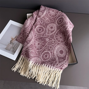Detailed view of burgundy paisley pashmina shawl with ivory tassels on display