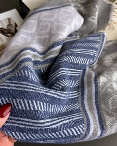 Detailed texture of a floral cashmere scarf with classic stripes and fringe accents