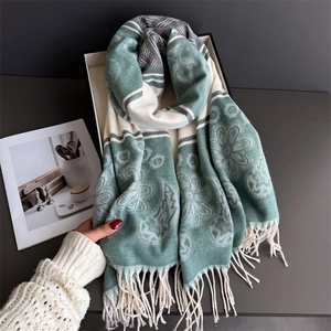 Detail of floral paisley scarf with soft tassels on a minimalist tray background