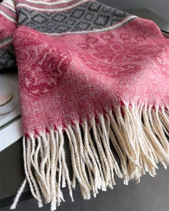 Detailed macro view of pink and grey floral jacquard pashmina with fringed tassels