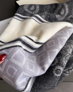 Detail of knit scarf showing patchwork geometric patterns and soft fringe texture