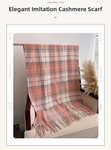 Détail d'une écharpe à carreaux orange effet cachemire avec des franges sur un fauteuil