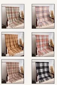Detail view of plaid cashmere scarves with fringe in green, blue, and neutral tones