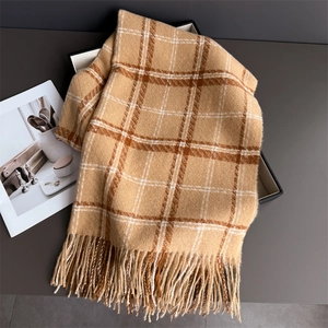 Détail d'une écharpe en cachemire à carreaux camel avec franges et texture douce