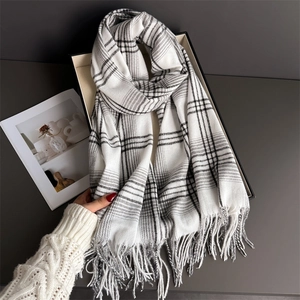 Detailed close-up of soft black and white checkered scarf with elegant fringe edges