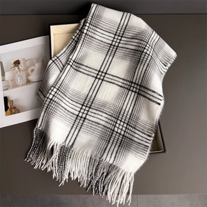 Detail shot of the thick cashmere-like texture and tassel edges on the checkered scarf