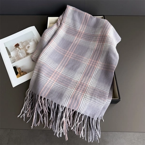 Close-up of checkered cashmere-feel scarf texture and fringe detail in soft grey