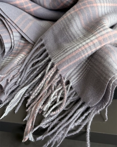 Detail of gray and pink checkered scarf showing soft woven texture and fringe edges