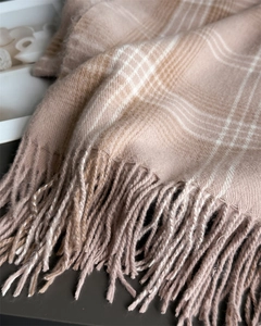 Close-up of checkerboard knit scarf featuring soft fringe tassels and plush cashmere texture