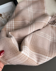 Close-up of soft checkered scarf featuring brushed cashmere texture and fringe tassels