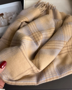 Close-up of soft plaid scarf with tassels, featuring khaki and purple checkered pattern