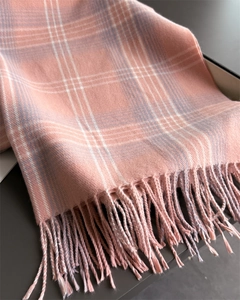 Detailed view of pink and lilac checkered scarf with soft cashmere-like texture and tassels