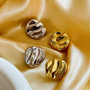 Irregular textured 18K gold and silver plated wave earrings on silk background