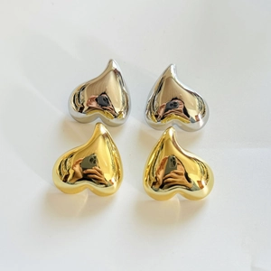 Vue à plat de boucles d'oreilles cœur plaquées or 18 carats et argent effet miroir