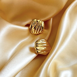 Set of two vintage gold-tone croissant rings with textured vertical stripes on satin fabric