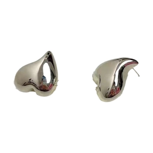 Boucles d'oreilles cœur en argent poli avec un design en métal torsadé abstrait sur fond blanc