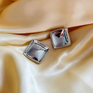 Boucles d'oreilles carrées géométriques en argent poli sur tissu en soie dorée