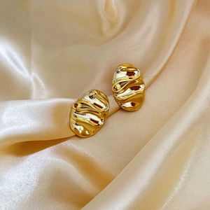 Irregular 18K gold plated geometric ripple earrings on elegant silk fabric background