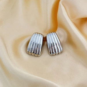Polished silver trapezoid earrings with vertical stripes on elegant silk background
