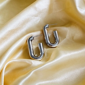Polished 18K gold plated geometric U-shaped drop earrings on elegant satin fabric