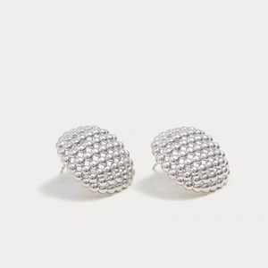 Detailed view of silver hollow geometric earrings with textured micro-bead surface finish