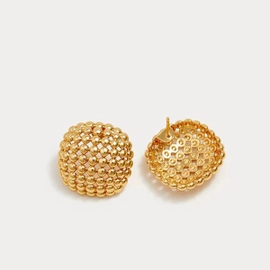 Detail of gold hollow dome stud earrings with textured bead surface and stud post