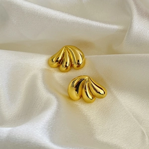 Macro detail of 18K gold-plated geometric droplet earrings with textured wavy design