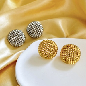 Detail view of hollow geometric beaded sphere earrings in gold and silver finish