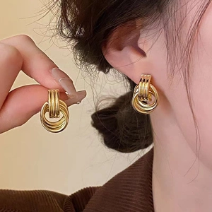 Minimalist 18K gold plated multi-layer geometric hoop earrings shown on ear and in hand
