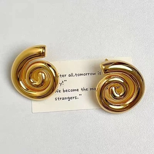 Gros plan de boucles d'oreilles en cuivre plaqué or 18 carats au design en spirale